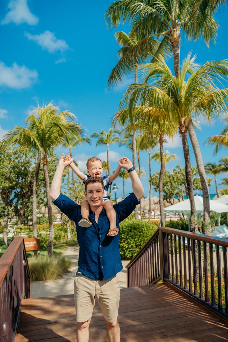 Dad and son among palm trees, Aruba