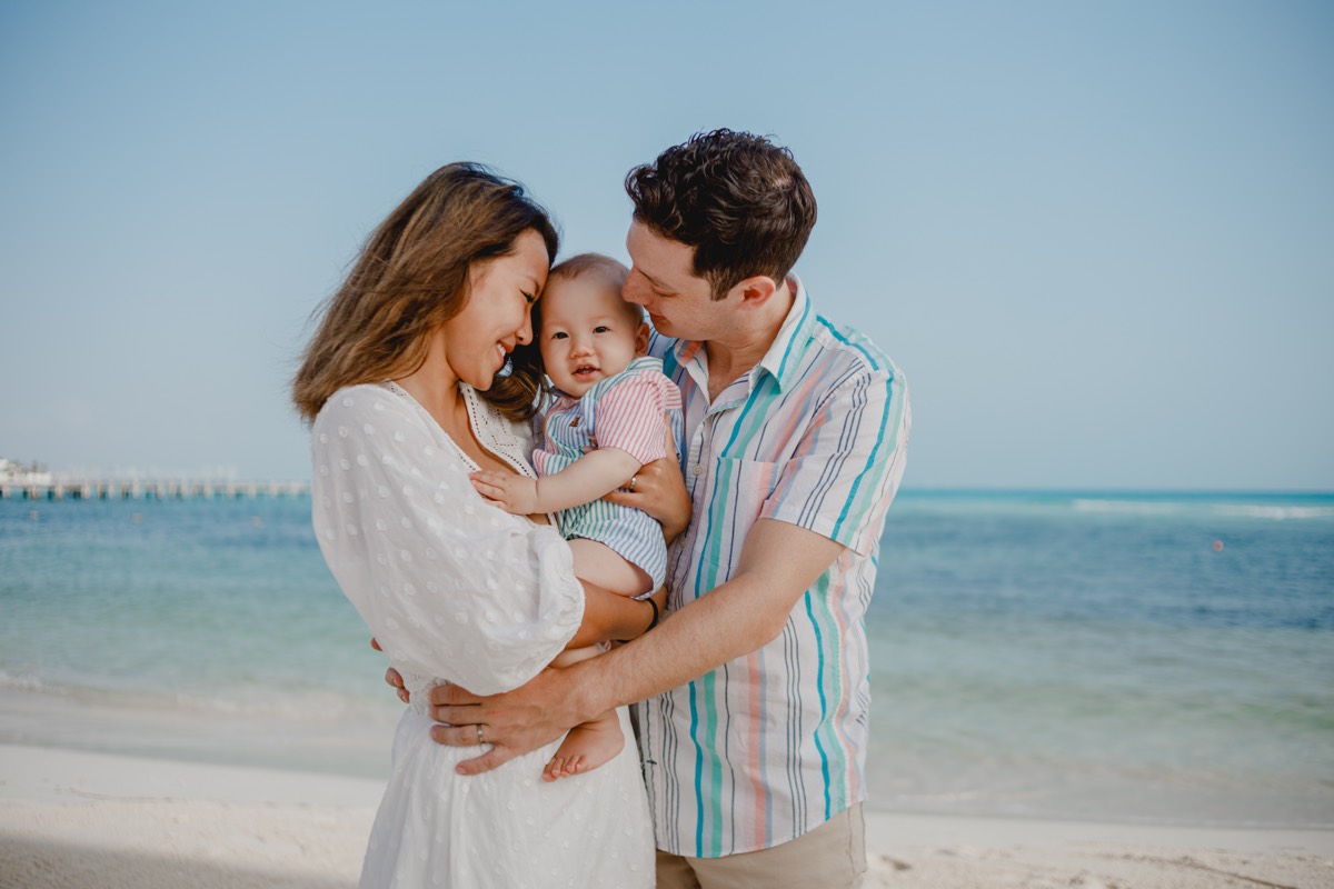 Parents holding their baby on the beach, Cancún