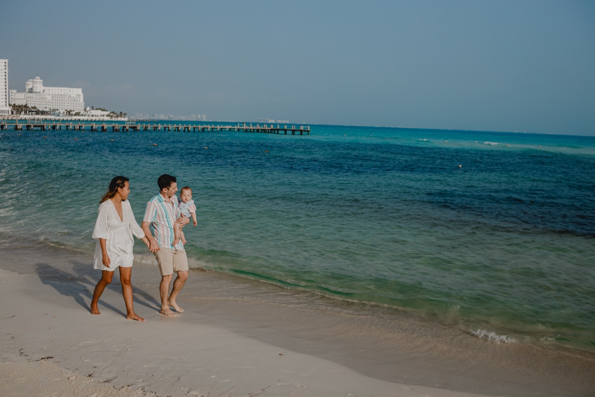 Family walking the beach toward the resort